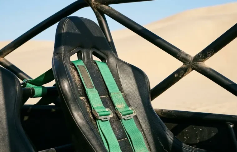 A professional four-point harness inspection before a Huacachina dune buggy tour sets off into the desert.